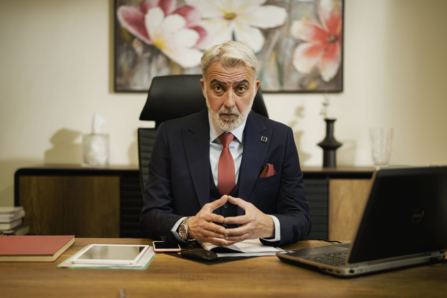 Professional businessman sitting confidently at his executive desk in an office setting.